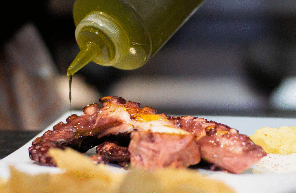 Neptuno, Mariscos frescos del día cerca de Cálig. Aceite siendo echado delicadamente sobre el pulpo.